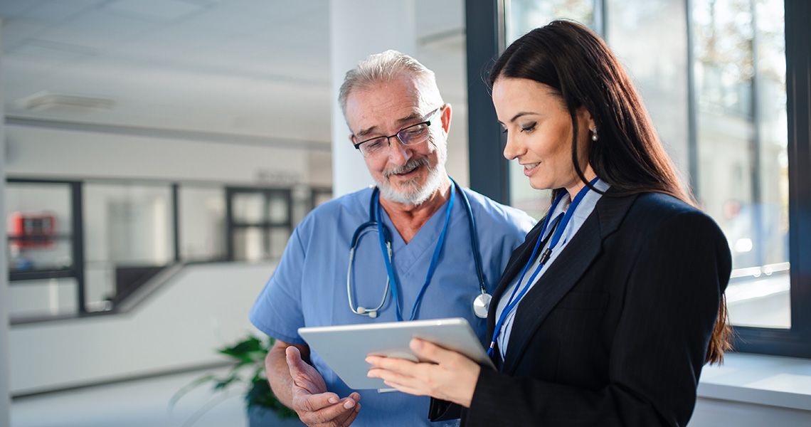  A regulatory affairs professional uses a tablet to share regulatory information with a medical researcher.