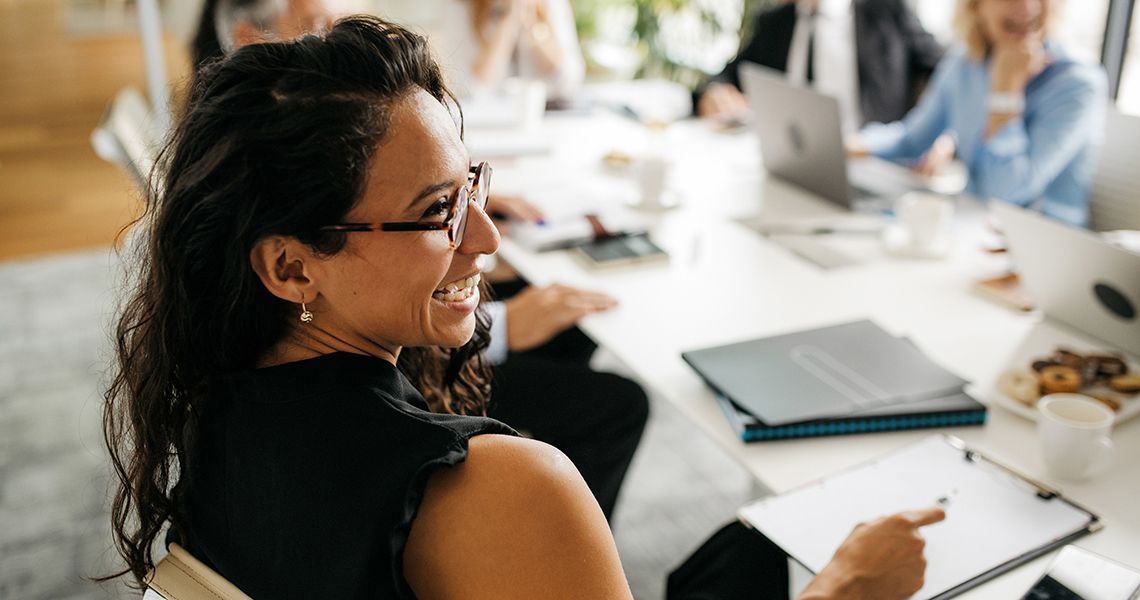 Person sitting at a meeting and smiling