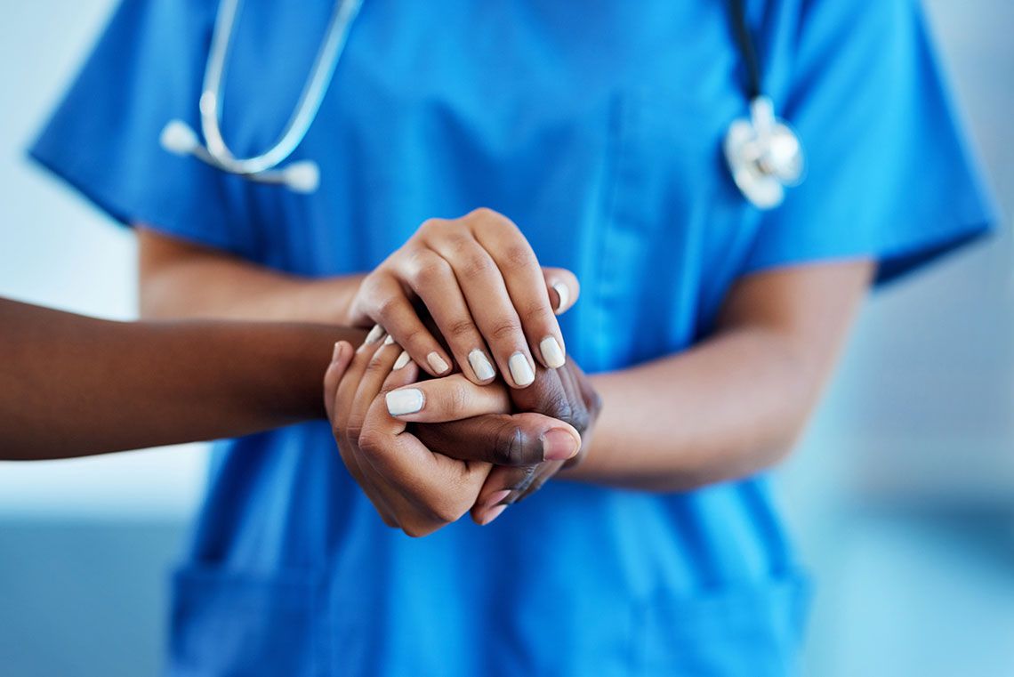 A medical professional holding a patient's hand