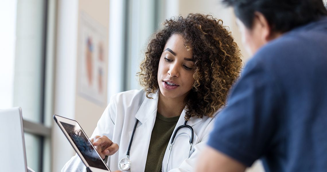 Doctor showing someone something on a tablet