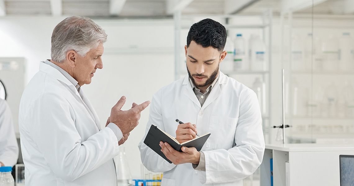 two doctors talking and one is writing in a notebook