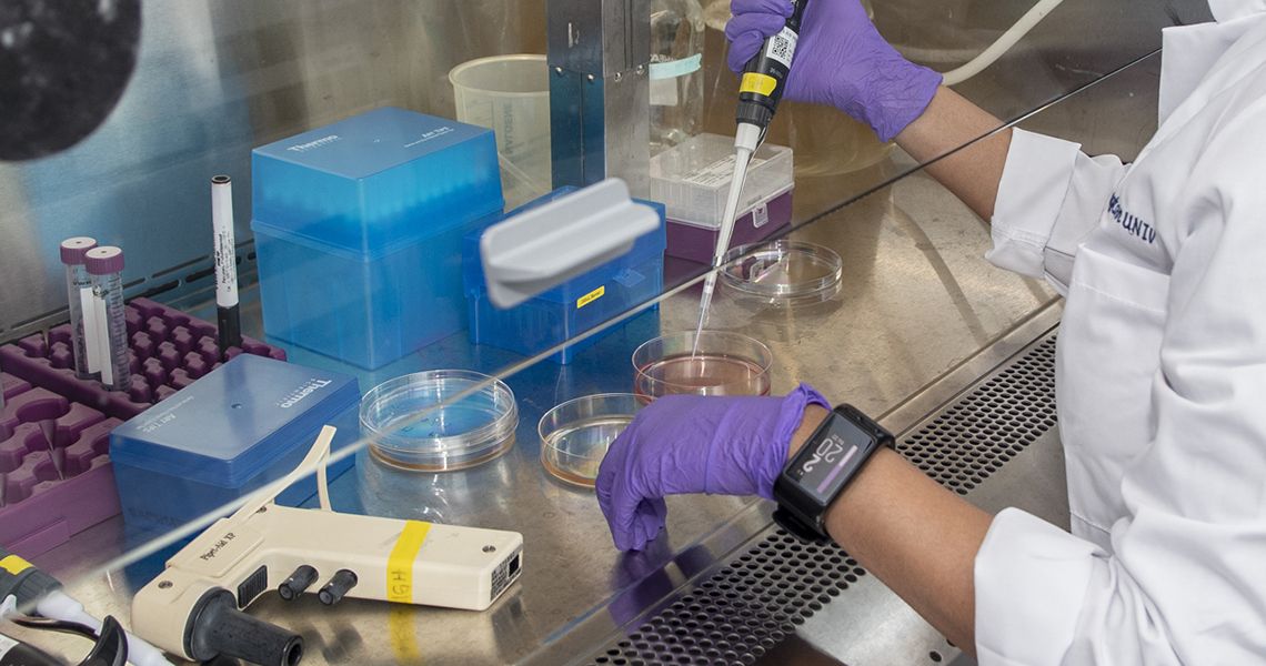 researcher using a pipette in a lab