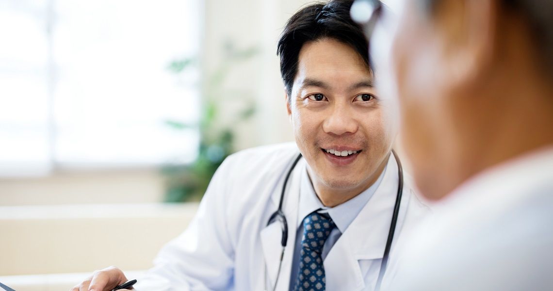 A male doctor speaks to a male