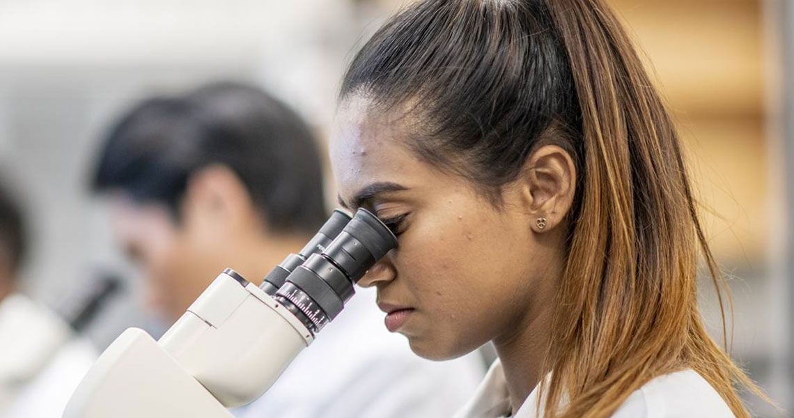 A researcher looking through a microscope