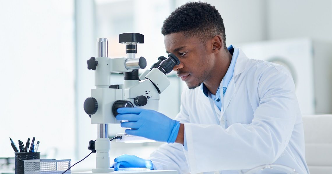 A man looks into a microscope