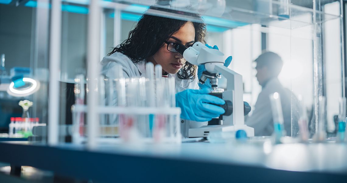 Scientist looking into a microscope in a lab