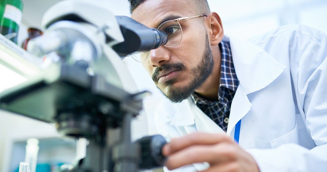 A man looks into a microscope