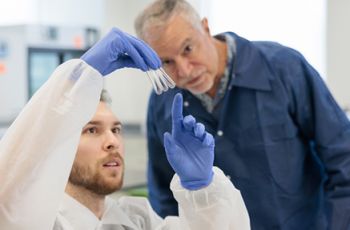 Professor examining vials with student in biomedical laboratory science program