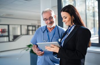  A regulatory affairs professional uses a tablet to share regulatory information with a medical researcher.